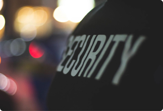 A blurry image of the back of a security guard 's uniform.