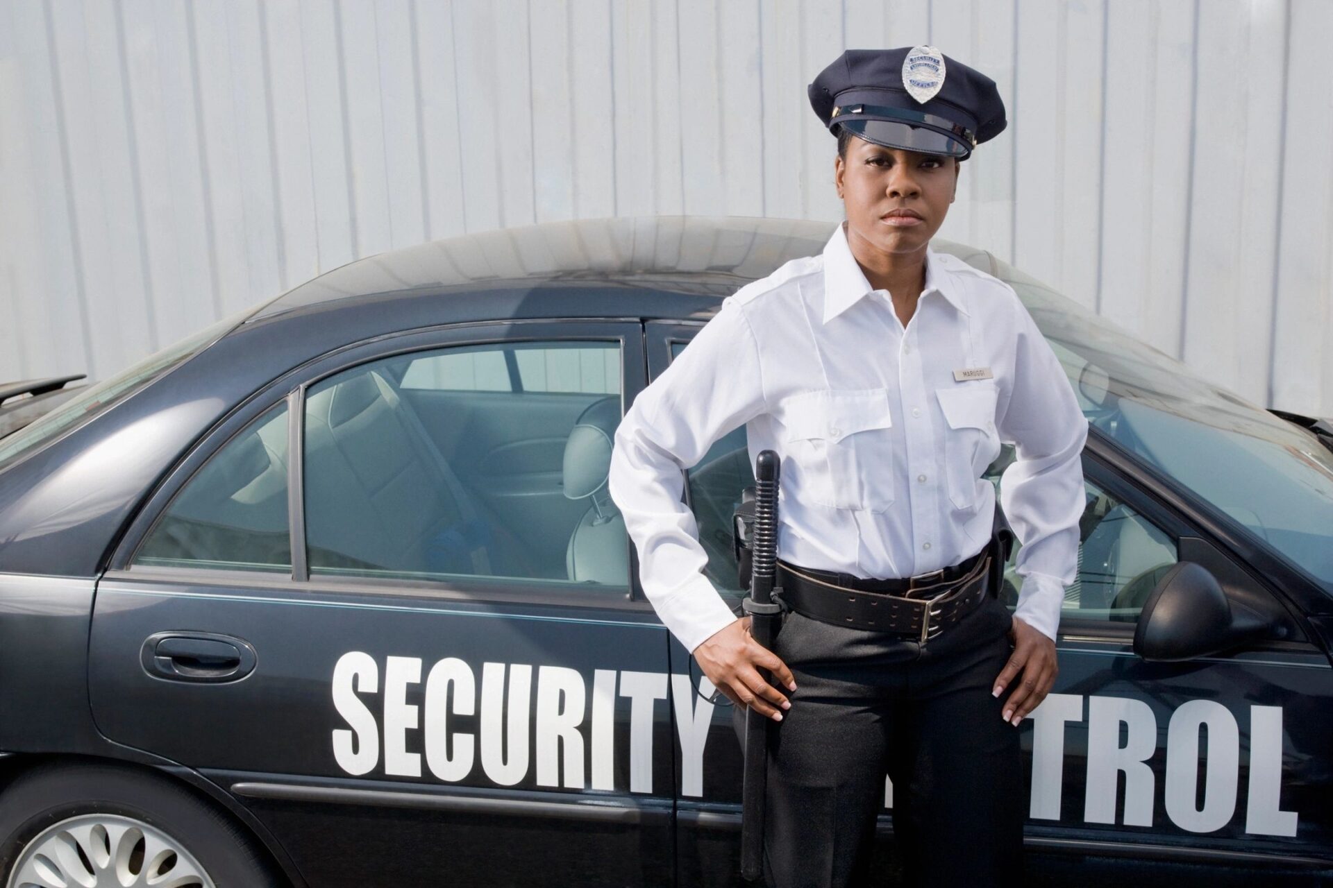 A security guard standing next to a car.